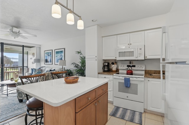 kitchen featuring pendant lighting, light tile patterned flooring, white appliances, ceiling fan, and white cabinets