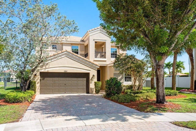 2261 Balsan Way, Wellington, FL 33414 - view of front of house featuring a balcony, stucco siding, an attached garage, decorative driveway, and a tile roof