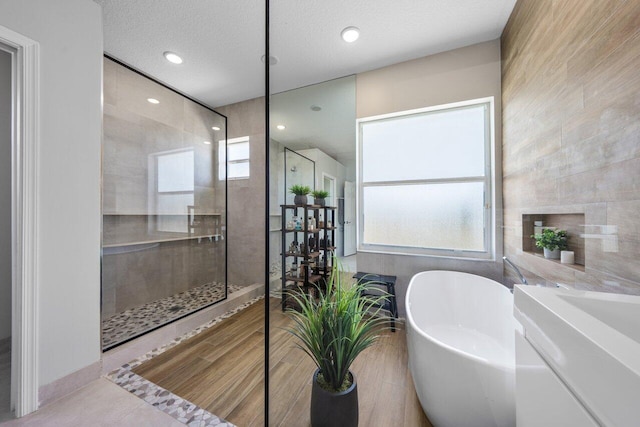 2261 Balsan Way, Wellington, FL 33414 - bathroom featuring a soaking tub, walk in shower, recessed lighting, tile patterned flooring, and a textured ceiling