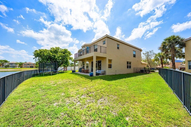 2261 Balsan Way, Wellington, FL 33414 - back of property featuring stucco siding, a trampoline, a balcony, and a patio