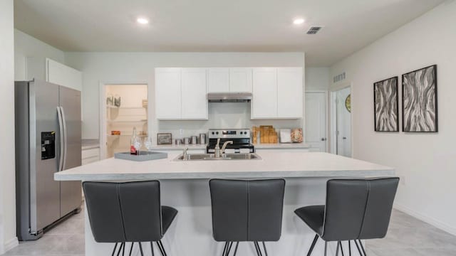 kitchen featuring visible vents, stainless steel appliances, under cabinet range hood, and white cabinets