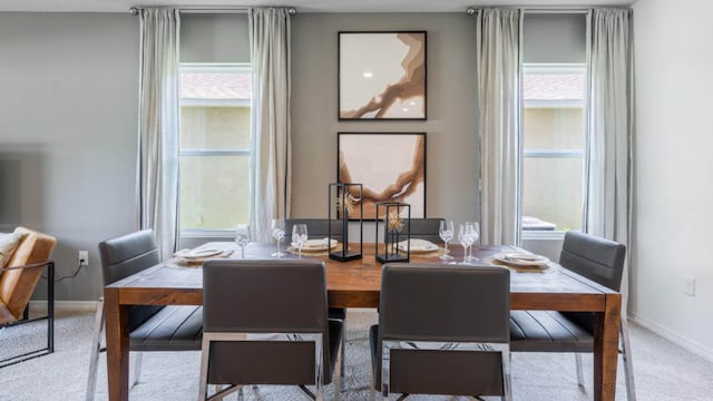 dining area featuring baseboards, a healthy amount of sunlight, and carpet floors
