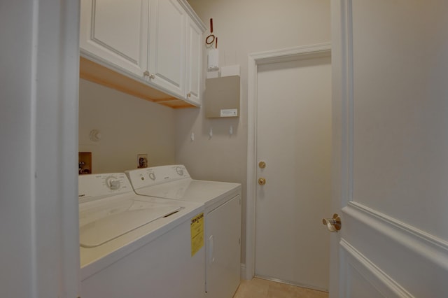 laundry area with cabinet space, washing machine and clothes dryer, and light tile patterned floors