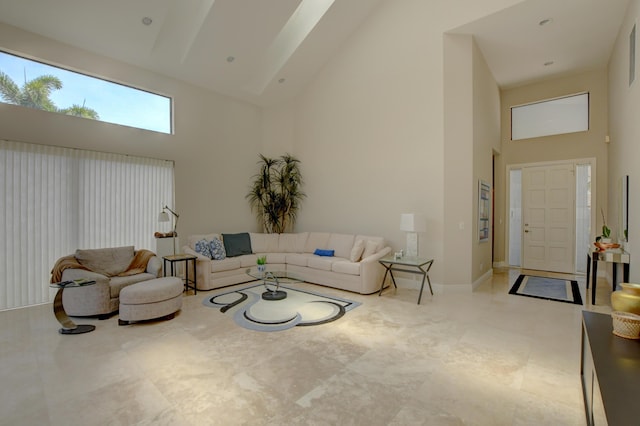 living area featuring baseboards and high vaulted ceiling