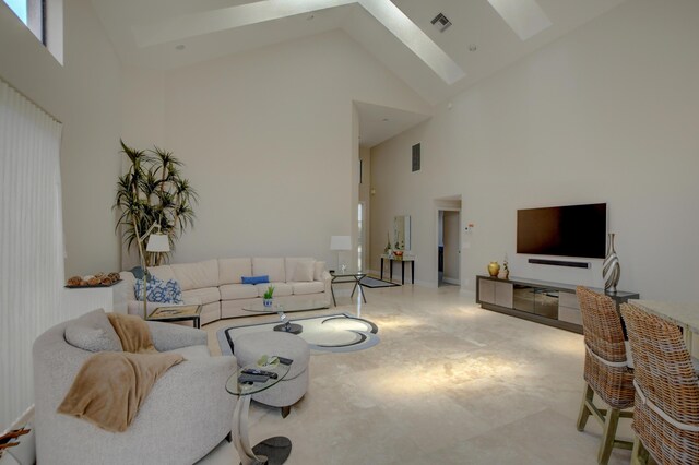 living area featuring a skylight, visible vents, and high vaulted ceiling