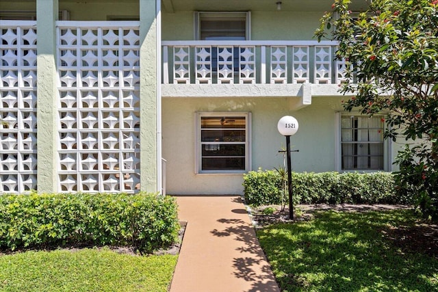 1521 NW 19th Ter Unit 101, Delray Beach, FL 33445 - view of exterior entry with a balcony and stucco siding