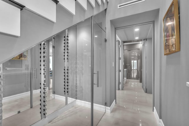 wine room featuring visible vents, baseboards, and light tile patterned floors
