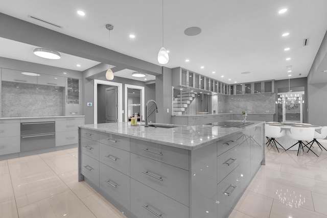 kitchen featuring black electric stovetop, a large island, gray cabinetry, and modern cabinets