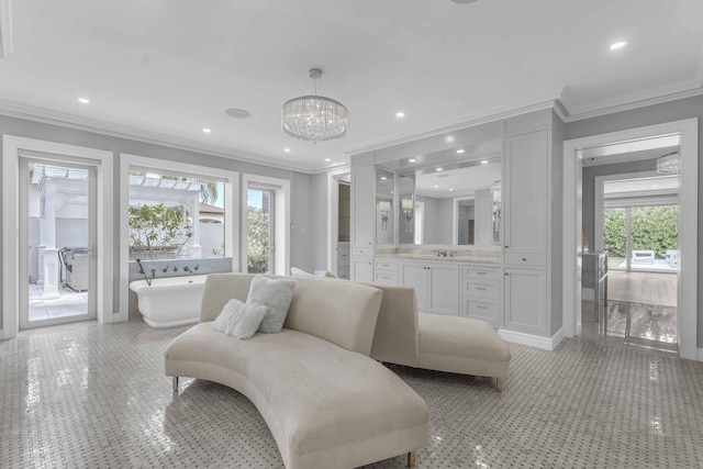 living room with an inviting chandelier, ornamental molding, and plenty of natural light