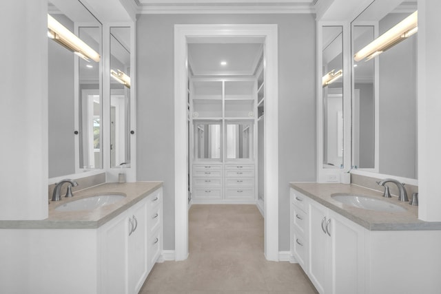bathroom with two vanities, crown molding, and a sink