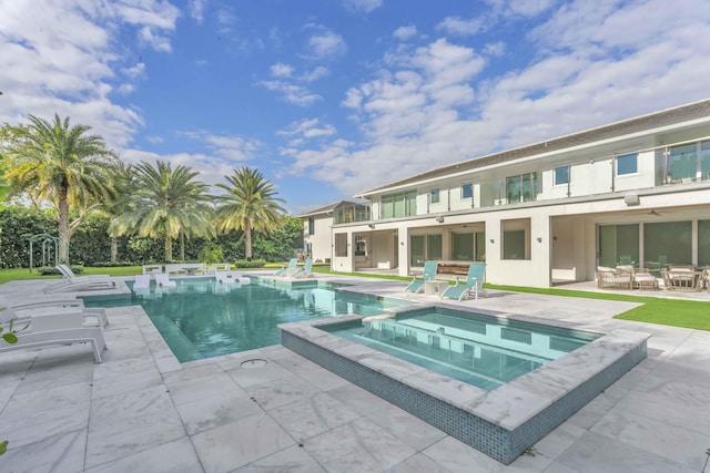 view of pool with a patio area and a pool with connected hot tub