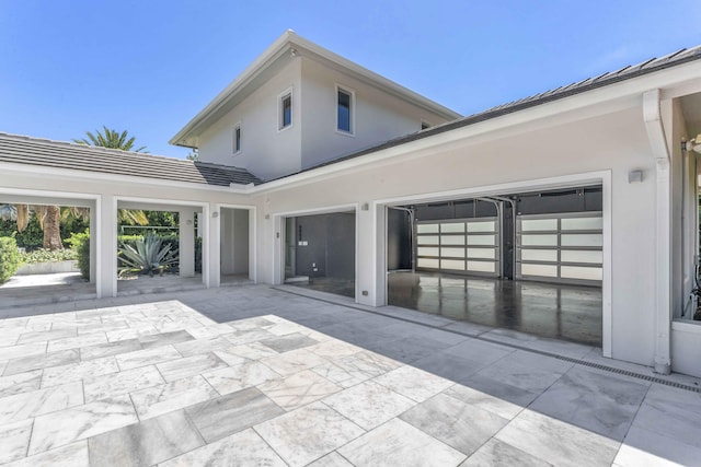 rear view of house featuring stucco siding and a patio