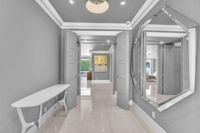 hall featuring baseboards, crown molding, and light tile patterned floors