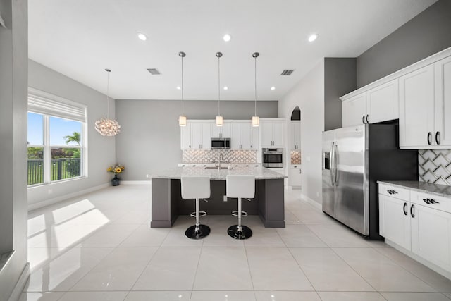kitchen featuring appliances with stainless steel finishes, tasteful backsplash, baseboards, and a sink