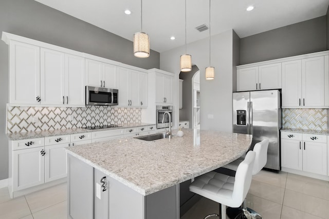 kitchen with appliances with stainless steel finishes, light tile patterned flooring, visible vents, and backsplash