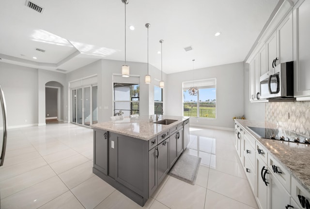 kitchen with a sink, decorative backsplash, stainless steel appliances, light tile patterned floors, and visible vents