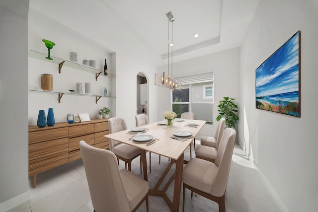 dining room featuring light tile patterned flooring, arched walkways, an inviting chandelier, and baseboards