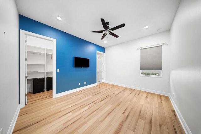 interior space featuring a closet, baseboards, wood finished floors, and a spacious closet