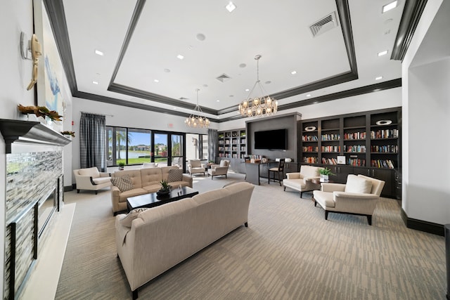 carpeted living room with visible vents, a chandelier, crown molding, and a tray ceiling