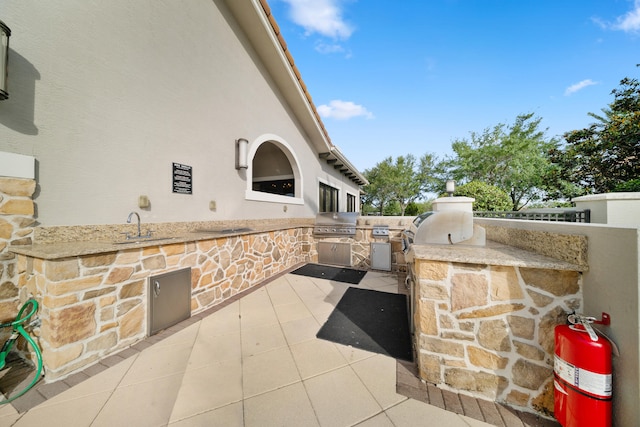 view of patio / terrace with a grill, exterior kitchen, and a sink