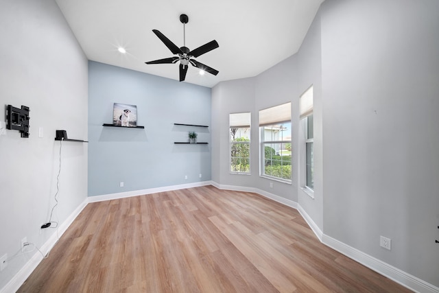 empty room featuring baseboards, wood finished floors, and a ceiling fan
