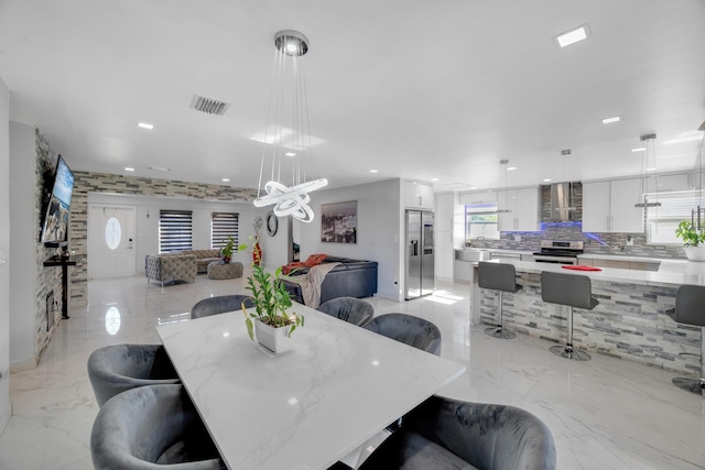 dining room with a chandelier, visible vents, recessed lighting, and marble finish floor