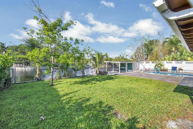 view of yard with a fenced in pool, a fenced backyard, and a water view