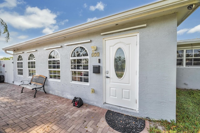 entrance to property featuring a patio area and stucco siding