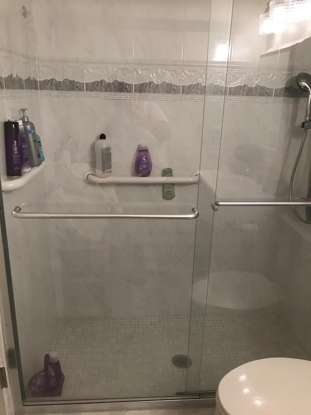 full bath featuring toilet and a stall shower