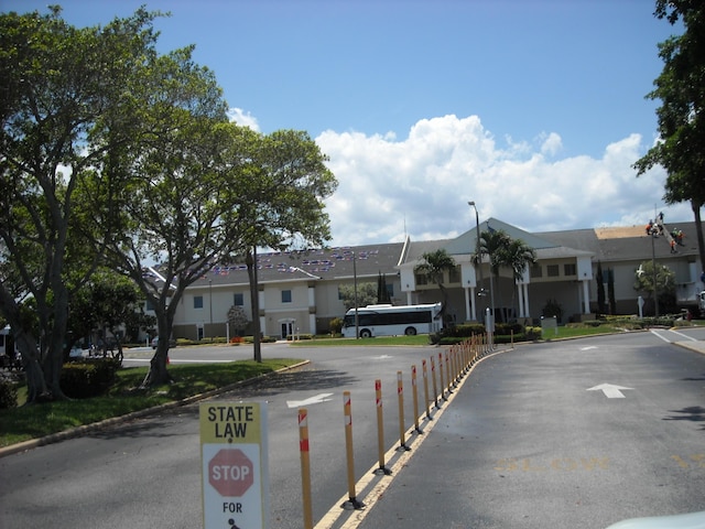 view of asphalt road with a residential view, street lighting, and curbs