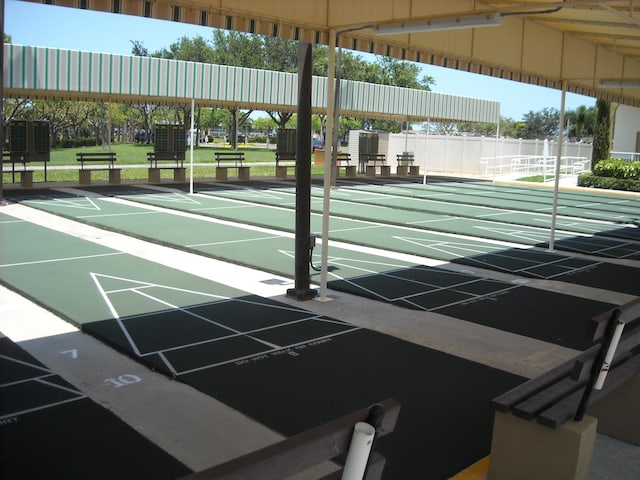 surrounding community with fence and shuffleboard