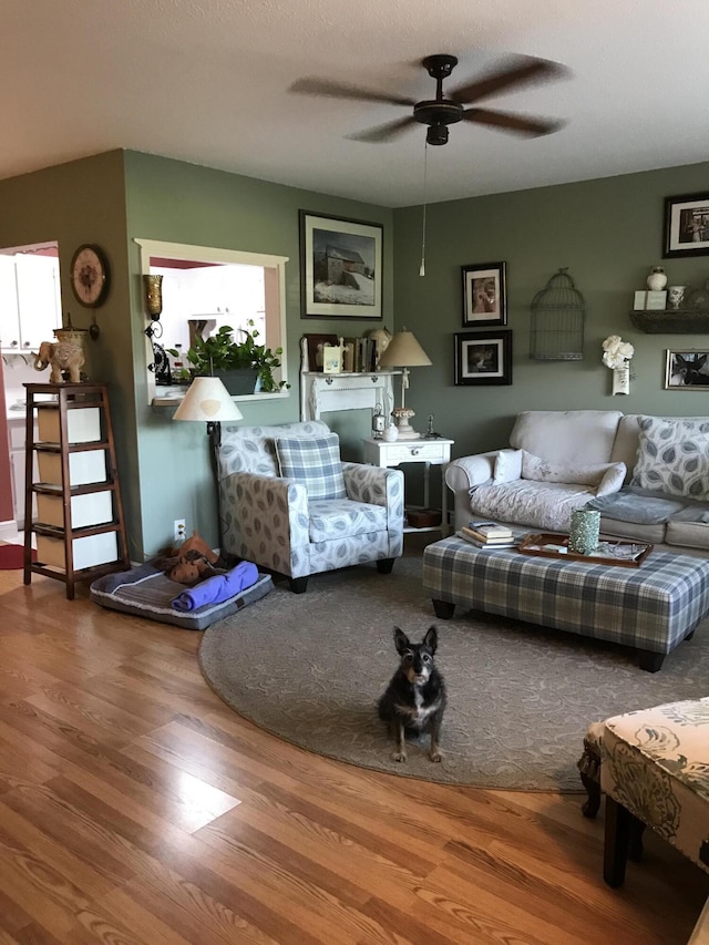 living area with wood finished floors and ceiling fan