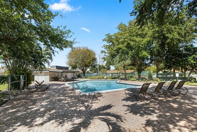 pool with fence and a patio