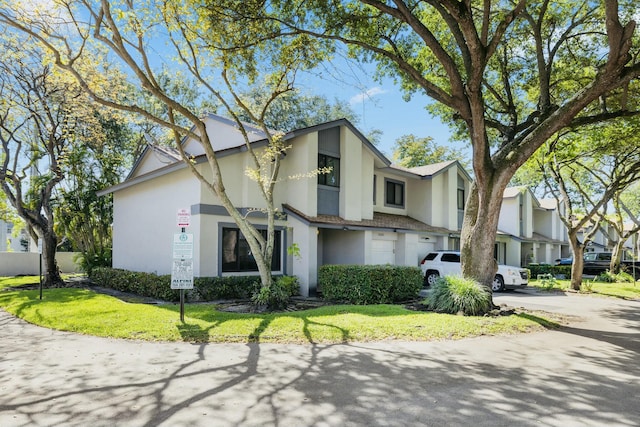 view of property featuring a front yard and stucco siding