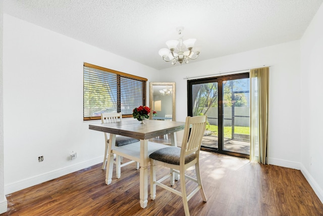 dining room with baseboards, a notable chandelier, wood finished floors, and a textured ceiling