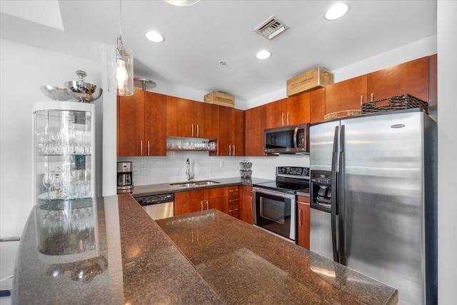 300 S Australian Ave Unit 717, West Palm Beach, FL 33401 - kitchen featuring stainless steel appliances, brown cabinetry, tasteful backsplash, recessed lighting, and decorative light fixtures