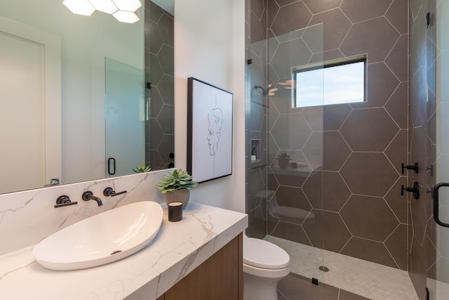 full bath featuring a tile shower, toilet, and vanity