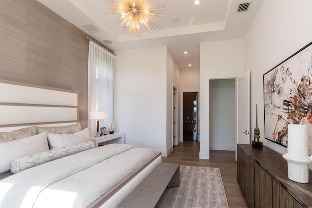bedroom featuring baseboards, visible vents, recessed lighting, wood finished floors, and a raised ceiling