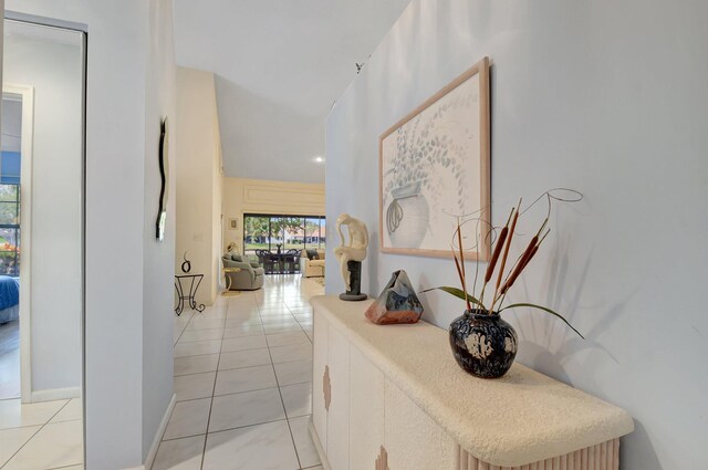 hall featuring light tile patterned floors and baseboards