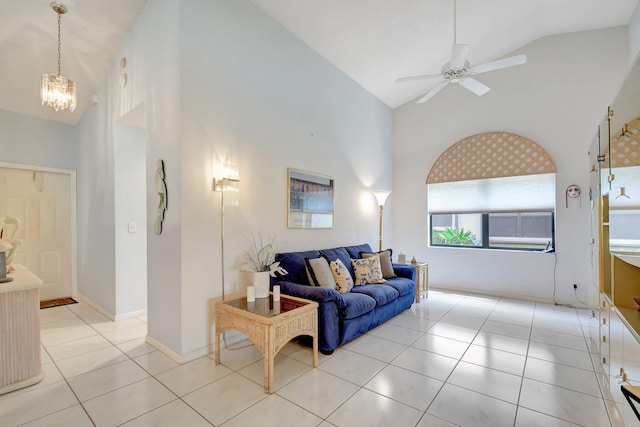 living area featuring light tile patterned floors, high vaulted ceiling, and ceiling fan with notable chandelier