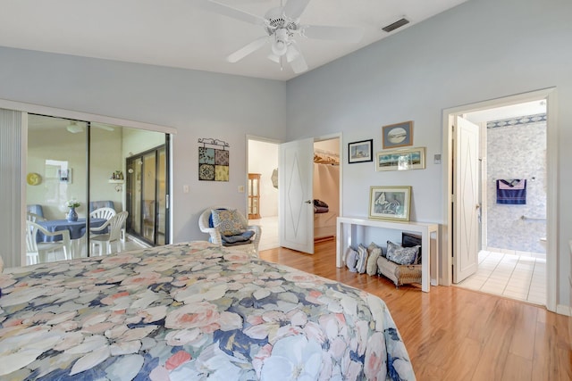 bedroom featuring wood finished floors, ensuite bath, a closet, a walk in closet, and visible vents