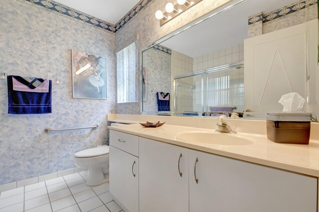 bathroom with tile patterned floors, wallpapered walls, a shower stall, toilet, and vanity