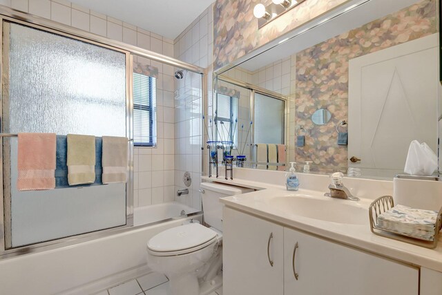 bathroom featuring enclosed tub / shower combo, toilet, and vanity