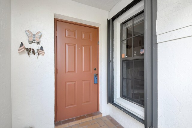 doorway to property featuring stucco siding
