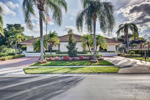 view of front facade with concrete driveway, stucco siding, and a tiled roof