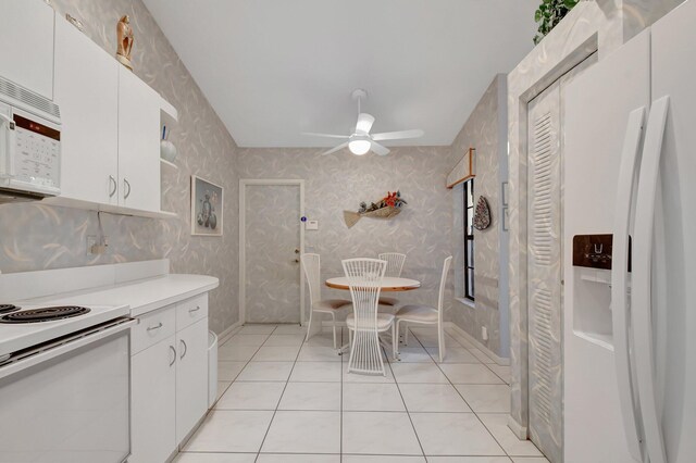 kitchen with light tile patterned floors, ceiling fan, white appliances, and white cabinets