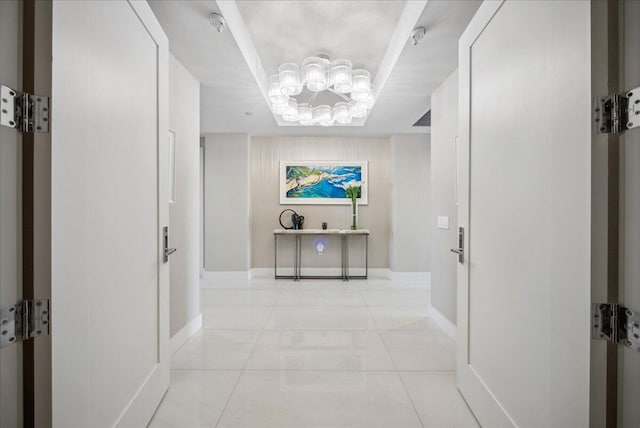 5000 N Ocean Dr Unit 603, Singer Island, FL 33404 - hallway featuring baseboards, a chandelier, and light tile patterned floors