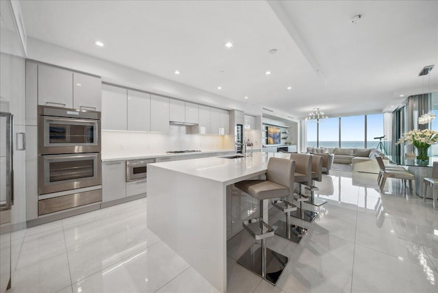 5000 N Ocean Dr Unit 603, Singer Island, FL 33404 - kitchen featuring a sink, open floor plan, modern cabinets, light countertops, and double oven