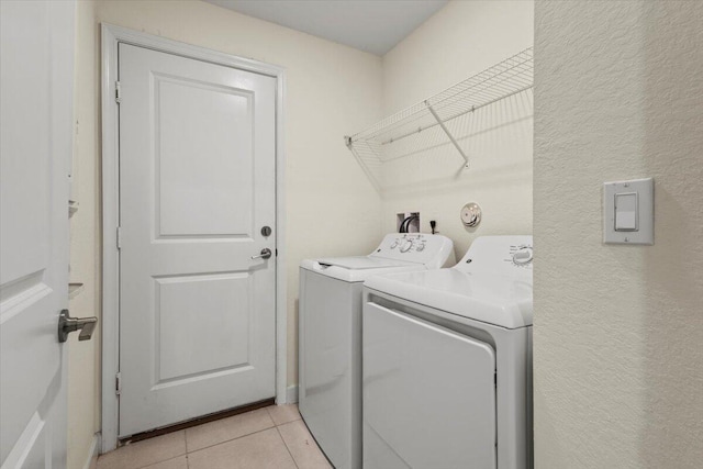laundry area with washing machine and dryer and light tile patterned flooring