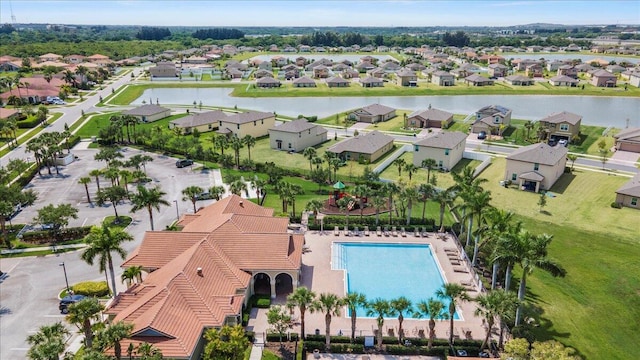 aerial view of residential area featuring a nearby body of water and a pool area